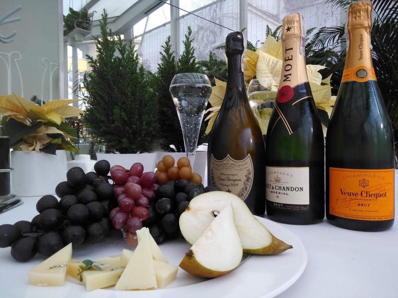 Butelki wina i sery z owocami podane do stołu w restauracji